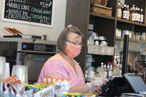 Megan Broome/The Clayton Tribune. Teka Earnhardt, manager of The Market on Main Street in Clayton, wears a mask and gloves to take a customer’s order. She said that employees are being extra cautious when it comes to safety and wash their hands often amidst the COVID-19 pandemic. 