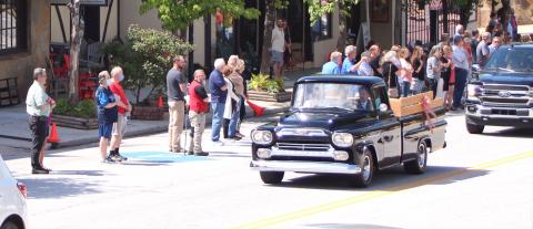 Megan Broome/The Clayton Tribune. The body of Lewis Reeves, Jr. was taken past Reeves Hardware a final time Saturday in a restored Reeves pickup truck as employees and members of the community pay their respects. 