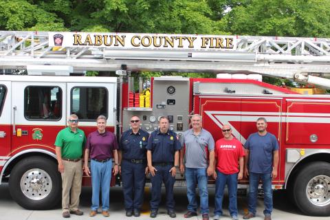 Megan Broome/The Clayton Tribune. Rabun County Fire Services put the county’s first ladder truck into service recently. It responds to fire and rescue calls across the county. Pictured from left are Darrin Giles, county administrator, Greg James, commissioner chairman, James Reed, fire chief, Justin Upchurch, assistant fire chief, and Commissioners Kent Woerner, Scott Crane and Will Nichols.