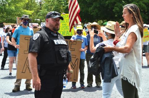 Wayne Knuckles/The Clayton Tribune. Clayton Police Chief Andy Strait, left, talks with vigil organizer Sarah Gillespie before the start of Saturday's Silent March. 