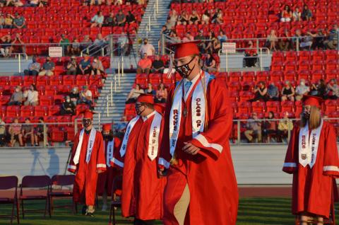 Wayne Knuckles/The Clayton Tribune. Under fair skies and a nearly-full moon, the Rabun County High School Class of 2020 received diplomas Saturday at Frank Snyder Memorial Stadium. Pictured: Andrew O'Brien, left, Cole Littrell and Will Hightower take their places. 