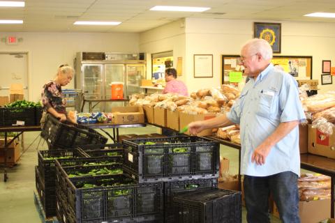 Megan Broome/The Clayton Tribune. Carl Green works to move boxes and organize food to be distributed to residents of the community at the American Legion Post 220 food distribution last Thursday. 