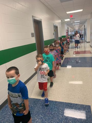 Photo courtesy Rabun County Schools. Jax Jackson, left, Asher Justice, Jordan Whipple and Kasi Jai Blalock from Mrs. Moore’s kindergarten class stand single-file in the hallway wearing masks during the first week of school as part of COVID-19 safety measures in the school system. One-direction hallways are part of the “new normal” for the school year. 