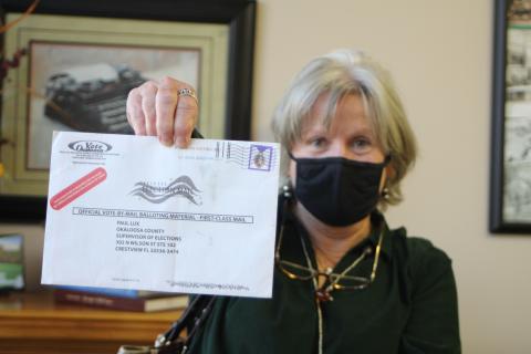 Megan Broome/The Clayton Tribune. Voter Pamela Wawrzyk holds up an absentee ballot that was returned by the post office for an unknown reason. She said that she and her husband Stephen found the ballot in their mailbox when they came back from Florida and it had no indication of the reason it was returned. She cautioned voters to be sure and check their ballot status to make sure their ballot is received by the elections office for their vote to be counted. 