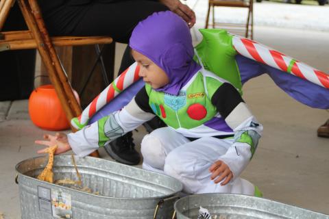 Megan Broome/The Clayton Tribune. Daniel Contreras dresses as Buzz Lightyear and plays one of the games at the Fall jamboree in Clayton Halloween night. 
