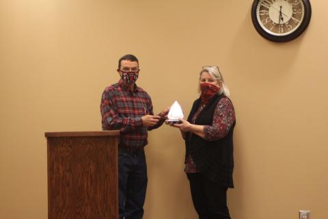 Megan Broome/The Clayton Tribune. Board of Education Chairman Steve Cabe, left, presents an award to Tax Commissioner Sandy Smith at last Thursday’s meeting. The award was presented on behalf of Board of Education members to thank Smith for her hard work during her career.  Her department’s tax collections contribute to the amount of funding Rabun County Schools receives, Superintendent April Childers explained. Smith is retiring at the end of the year. 