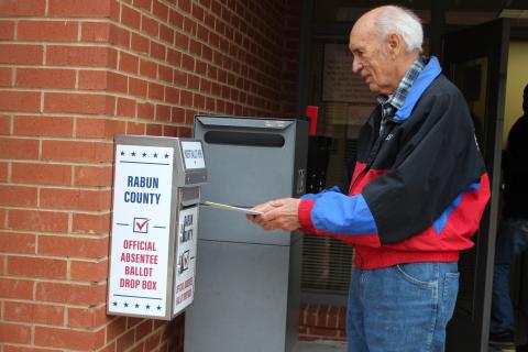 Megan Broome/The Clayton Tribune. Voter J.P. Miles returns his absentee ballot to the designated box in front of the Board of Elections Office on Monday. The office is located at 18 Old Raco Dr., Suite 105, Clayton. 