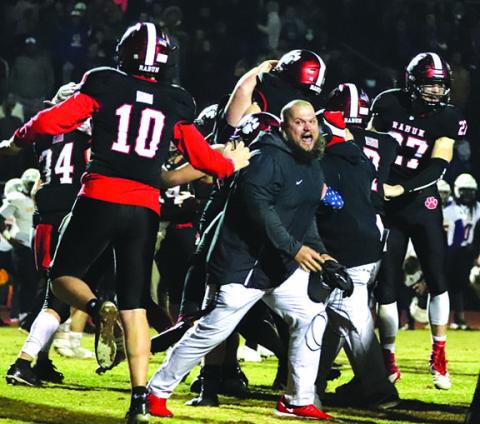 Rabun County Assistant Coach JayJay White joins the celebration after the Wildcats defeated Bleckley 27-24 in overtime last week. The Wildcats need to win one more game Friday night to earn the right to travel to Atlanta and play for a state championship. 