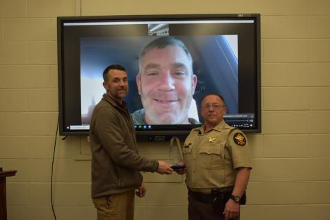Photo courtesy Rabun County Sheriff’s Office. Chief Deputy Scott Cheek, left, presents the Deputy of the Year award to Deputy Tony Parrish in December. Sheriff Chad Nichols participates via video call. 