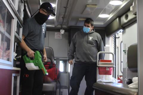 Megan Broome/The Clayton Tribune. Rabun County EMS Paramedics David Jones, left, and Jon Wilbanks decontaminate the back of an ambulance with a spray disinfectant at Station 1 before responding to a call. All ambulances and equipment are brought to the station to be decontaminated after every call as part of safety measures during an uptick in coronavirus cases in the county.