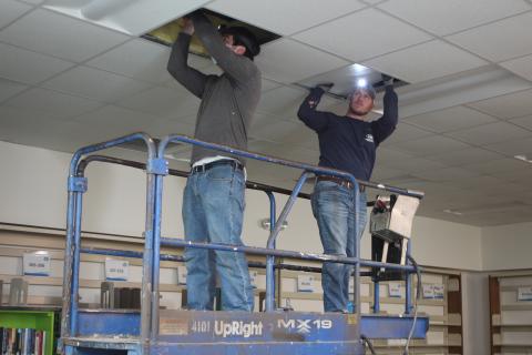 Megan Broome/The Clayton Tribune. Jacob Reynolds, left, and Payton Hunter with Hunter Electric install LED lights at the Rabun County Library. Frick said that this new lighting will be more energy-efficient. 