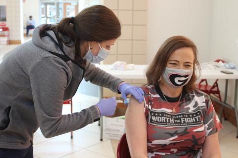 Megan Broome/The Clayton Tribune. Carla Kilby, second grade teacher at the Primary School, right, receives a Moderna vaccine from Gwen Stiles, RN in the OR and outpatient services at Mountain Lakes Medical Center, at last Friday’s vaccine clinic held in the Rabun County Schools Fine Arts Building. 