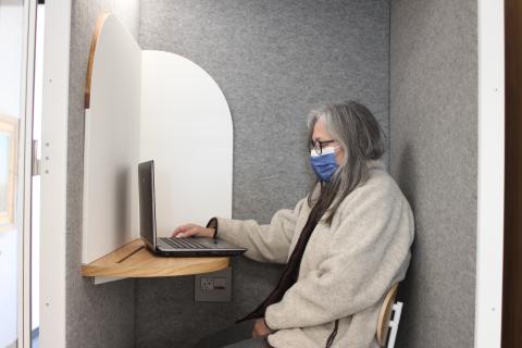 Megan Broome/The Clayton Tribune. Library patron Marce Lacouture utilizes one of the new pods for a video-conferencing call on Monday. 