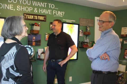 Megan Broome/The Clayton Tribune. Anita Pittman, left, and Todd Webb, COO of ELK Group International, converse with new Chamber President Cliff Bussard at a meet-and-greet at the Rabun County Welcome Center on Monday.
