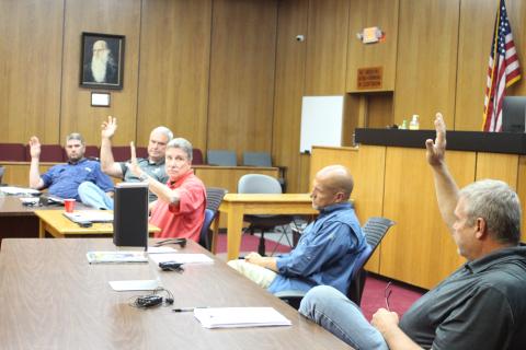 Megan Broome/The Clayton Tribune. Commissioners Will Nichols, left, Kent Woerner, Chairman Greg James, and Tom Garrison, far right, vote to approve a rezoning request from Taywood, LLC to rezone the property 8118 Bridge Creek Rd. from Agricultural to Commercial Business at Tuesday’s commission meeting. Commissioner Scott Crane voted against the motion. 