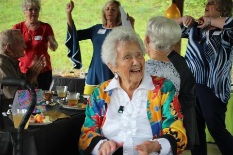 Megan Broome/The Clayton Tribune. Sky Valley resident Louise Kail smiles and cheers as a crowd of friends and family members sing her happy birthday for her 100th birthday at her party in Sky Valley on Sunday. 