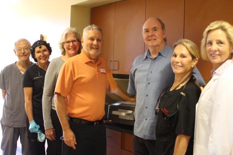 Megan Broome/The Clayton Tribune. Dr. Tom Callahan, left, Dr. Mollie Winston, Jane Janes, Tim Ranney, Dick Newkirk, Suzanne Newkirk and Dr. Janet Dunwoody stand in front of the new flash sterilizer in the Community Dental Clinic at the Rabun County Health Department. 
