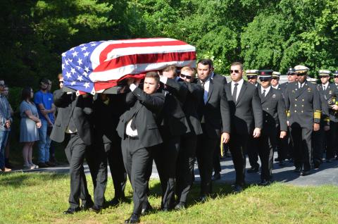 Wayne Knuckles/The Clayton Tribune. The body of Chandler Breck Patterson was brought to Betty's Creek Baptist Church last Friday for a Fireman's Farewell, which included the ringing of a fire bell and the "last call" over the radio.