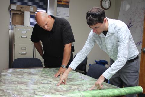Megan Broome/The Clayton Tribune. Brian Panell, new EMA director, left, and Troy Keenan, head of the Rabun County mapping department, look over a map of an area of Rabun County and brainstorm ideas of how to improve radio communication in the area.