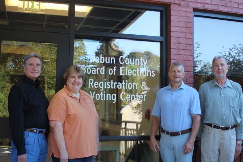 Megan Broome/The Clayton Tribune. Greg James, chairman of the Rabun County Board of Commissioners, left, Tammy Whitmire, Rabun County elections supervisor, Darrin Giles, Rabun County administrator, and Roy Lovell, Rabun County elections board member, pose in front of the new Rabun County Board of Elections Office. The new office is at 184 S. Main St. Suite 102, Clayton (below the health department). 