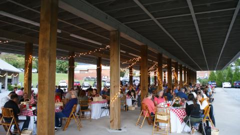 Photo courtesy of Elizabeth Adams. Guests enjoy a picnic style meal while listening to the Foxfire Boys at the Picnic for a Purpose. 