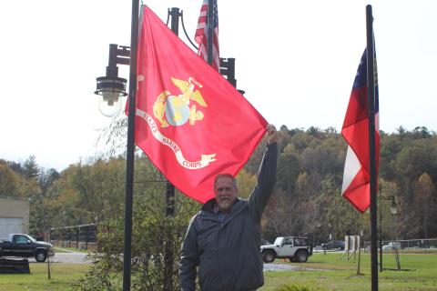 Megan Broome/The Clayton Tribune. John Bradshaw proudly holds a United States Marine Corps flag. 