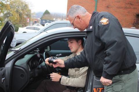 Megan Broome/The Clayton Tribune. Corporal Clinton Scott, left, and Captain Sam Jones install an in-car radar unit in a patrol vehicle at the Rabun County Sheriff’s Office.