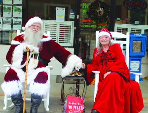Megan Broome/The Clayton Tribune. Santa Claus and Mrs. Hollie Claus greet children at the Better Homes and Gardens Real Estate company in Clayton on Dec. 17.