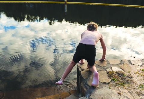 Photo courtesy of E. Lane Gresham. Sixth-grader Caleb Kelley of Demorest dips a toe into the chilly waters of Lake Tallulah on Dec. 15. Kelly, a first-year swim team member, was the first to enter the water for the Tallulah Falls School swim team’s 10th annual “Polar Plunge.”