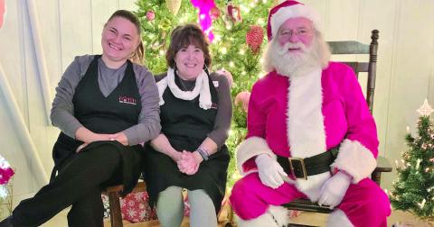 Photo courtesy of Jenifer Kulow/The Clayton Tribune. Dena Crane and Susan Kulow pose with Santa Claus at the Christmas Village of Lights event sponsored by FAITH last weekend. The event continues this weekend. Donations at the event benefit abuse victims.