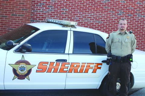 Megan Broome/The Clayton Tribune. Rabun County Sheriff’s Office Deputy Dakota Dills stands next to his patrol car. Dills was named the 2021 Deputy of the Year.