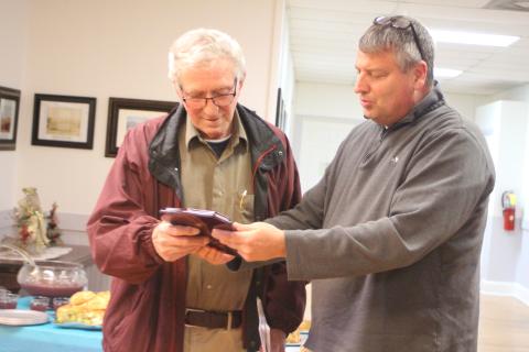 Megan Broome/The Clayton Tribune. Dillard City Council member Claude Dillard, right, presents Mayor Bill Robinson with a plaque on behalf of the city, thanking him for his 20 years of service as mayor, at a reception following Tuesday’s council meeting.