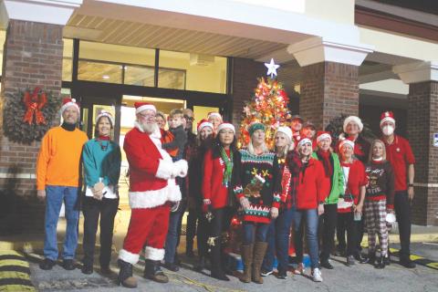 Megan Broome/The Clayton Tribune. Several volunteers in the community pass out presents, candy and Christmas cheer to children at the Christmas toy drive held at the Food Bank of Northeast Georgia last Friday.