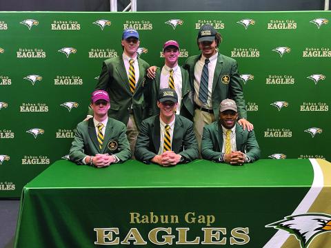 Submitted photo. Six Rabun Gap-Nacoochee School seniors sign letters of intent on Dec. 15 to play collegiately. Five of the Eagles signed to continue their football pursuits at major-college programs, and another signed for baseball. Seated (from left) are Tucker Holloway (Virginia Tech/football), Linus Zunk (Vanderbilt/football) and Buddy Howard (Western Carolina/baseball), while standing are Marlin Klein (Michigan/football), Coleman Bryson (Minnesota/football), and Darren Agu (Vanderbilt/football).