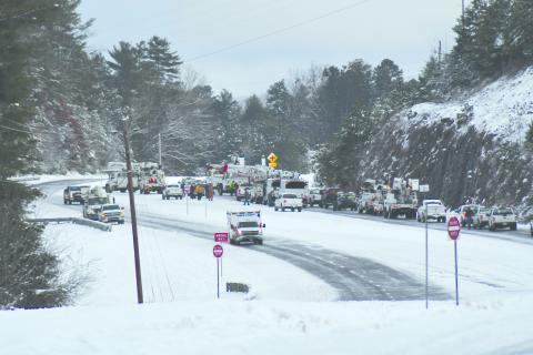 Enoch Autry/The Clayton Tribune. Utility crews work to clear Highway 441 North Monday morning outside the city limits of Clayton. 