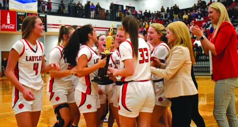 Enoch Autry/The Clayton Tribune. The Rabun County Ladycats celebrate with their region championship trophy they won on Feb. 18 with their defeat of Elbert County. The girls -- like the boys -- now are in the state AA tournament.