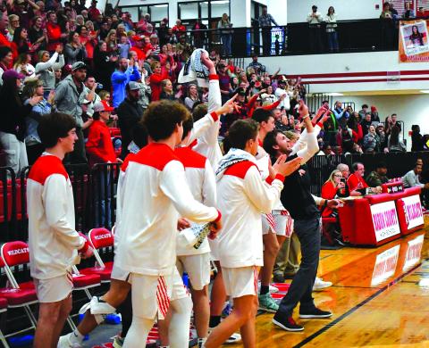 Enoch Autry/The Clayton Tribune. With his Wildcat bench and the Rabun County fans counting down the remaining seconds, head coach David Adcock points skyward as the RCHS boys claim a 67-55 win over visiting Therrell in round one of the Class AA state playoffs. 