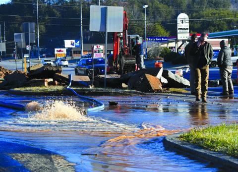 Enoch Autry/The Clayton Tribune. Water pours out into the parking lot from the Feb. 10 leak.