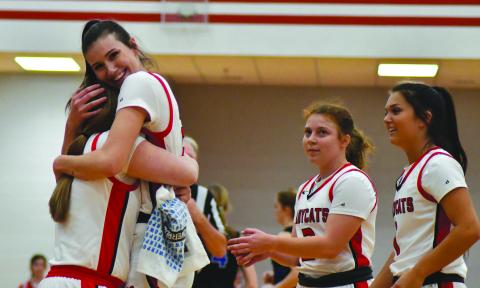 Enoch Autry/The Clayton Tribune. Gracie Deetz receives congratulations from her Ladycat teammates after scoring her 1,000 career point at the Feb. 11 home game against Banks County. 