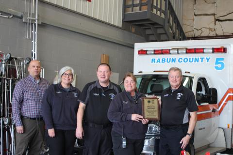 Megan Broome/The Clayton Tribune. Retiring EMT-I Stephanie Quilliams receives her honor from Mike Carnes, EMS/911 director (far right). Standing next to Quilliams, who retires with 26 years of service, are Lt. Brian Panell, Lt. Tammy Jones, and Capt. Trampes Stancil.