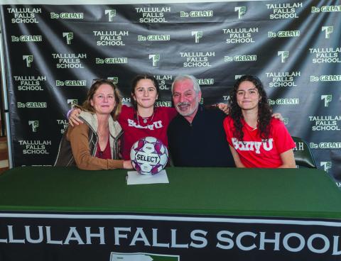 E. Lane Gresham/Tallulah Falls School. Tallulah Falls soccer player Honora Kahwach hugs her mother Kim Newberry and father Joseph Kahwach at the Feb. 9 letter of intent signing with Barry University. Sister Chloe Kahwach is seated on the far right. The senior has been a consistent leader for the Lady Indians.