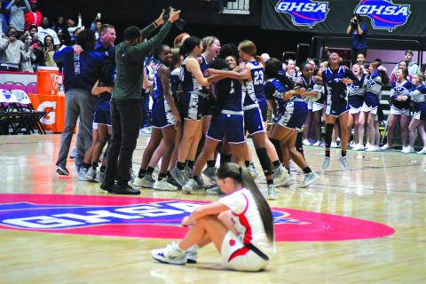 Enoch Autry/The Clayton Tribune. As Rabun County Ladycat senior Sophie Woodard sits on the court floor, the Elbert County Lady Blue Devils, cheerleaders and fans celebrate the school's first-ever state girls basketball championship on March 10.