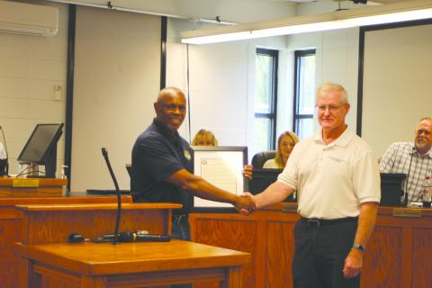 Megan Broome/The Clayton Tribune. Keith Owens, City of Clayton Wastewater Treatment Plant supervisor, left, accepts a Georgia Rural Water Association award for the hard work he and coworker Clint Harbin do for the city, presented by Dennis Brown, energy efficiency and plant organization specialist for the Georgia Rural Water Association.  The award was given after consulting with Brown on how to implement operating strategies at the Wastewater Treatment Plant that would result in energy-saving measures. 