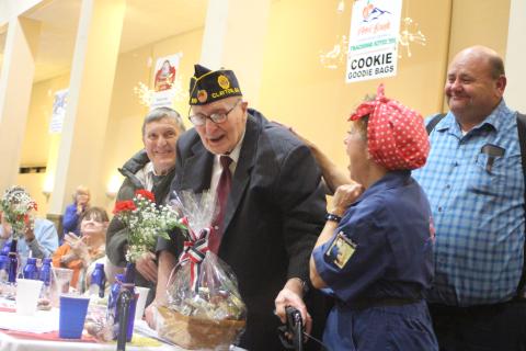 Megan Broome/The Clayton Tribune. Thomas Slowen, left, Carol Cain, dressed as Rosie the Riveter, and Anthony Worley congratulate Korean War Army Veteran Lloyd Hunter, as he is honored at the Veterans Appreciation Dinner held at the Rabun County Civic Center Nov. 11, 2021. Hunter is 93 years old and has owned Hunter Funeral Home since 1969. He is part of American Legion Post 220. He also worked in the Coroner’s Office for 52 years.