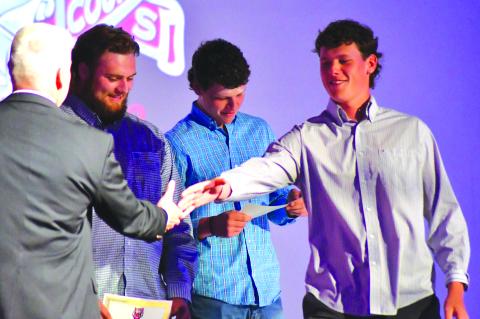 Enoch Autry/The Clayton Tribune. With his twin brother Conner Horton in the background, Garrett Horton receives his senior honors night recognition Tuesday as the Hortons were honored by RCHS athletic director Jason Gibson for signing golf scholarships to play at the University of North Georgia.