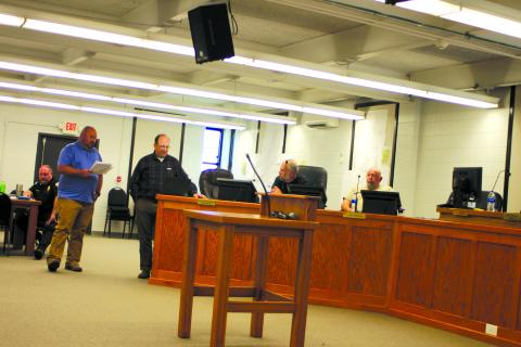 Megan Broome/The Clayton Tribune. Jason Waldroup, public works director for the city of Clayton, and Eric Neese, engineer for the city of Clayton, talk to Clayton council members at a council meeting earlier this year about the need to increase water rates for Clayton water customers. Council members unanimously approved an increase of 20 percent, which Walroup said increases customer monthly bills $5-$10. 