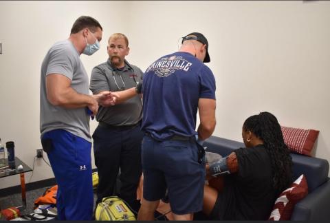 Submitted photo. Gainesville Fire Department Captain and Paramedic, and Clayton resident, Jordan Green, second from left, competes in the 2022 Georgia Police and Fire Games with fellow coworkers. The team took home second place in the Medic Challenge part of the games on June 23. Pictured are Eron Sunshine, program director for paramedic Studies at Lanier Technical College, Green, and Firefighter and Paramedic Josh Crawford, helping an actor during the Medic Challenge. 