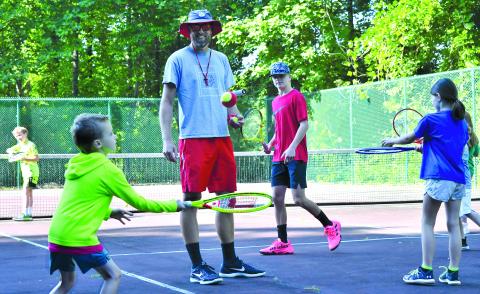 Enoch Autry/The Clayton Tribune. Rabun County High School head tennis coach Bryan Getty watches Tagg Bedingfield bounce the ball off his racket during a “Summer Tennis Camp” Monday at the Kingwood Golf Club & Resort tennis courts.