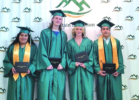 Megan Broome/The Clayton Tribune. Jocelin Lopez, Luke Edward Fowler-Berken, Shaylyn Sondra McGuffin and Andrew Zafra are all smiles as they pose with their diplomas after graduating from Mountain Education Charter High School June 16 at the RCHS FAB building. 