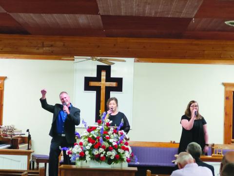 Megan Broome/The Clayton Tribune. Echoes of Mercy from Anderson, S.C., made up of Brian, Laura and Ashley Latham, sing worship music as the guest musicians for Bethel Baptist Church’s 130th Anniversary celebration July 17. 